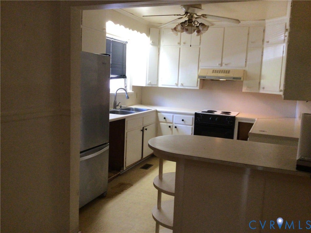 1307 Greystone Avenue, Richmond, VA 23224 Kitchen featuring white cabinetry, integrated peninsula with tiered shelving, stainless steel refrigerator, electric cooktop, and dual-basin sink with faucet