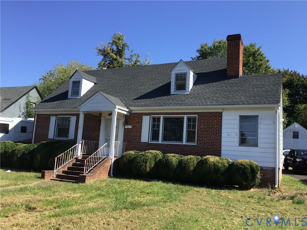 1307 Greystone Avenue, Richmond, VA 23224 Brick exterior featuring a gabled roof, two dormer windows, a chimney, and a covered front entryway with metal railings