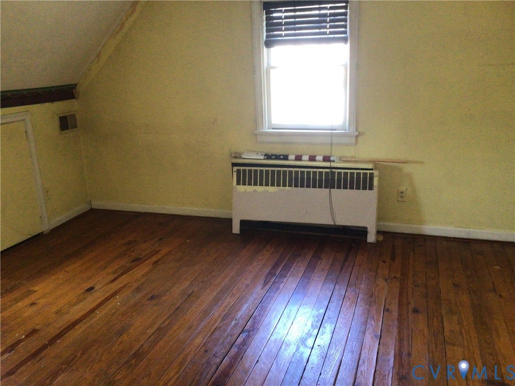 1307 Greystone Avenue, Richmond, VA 23224 Room featuring wood-finish flooring, a single window with blinds, and a built-in heating unit