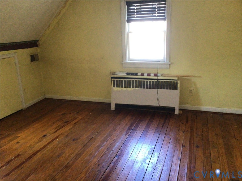 1307 Greystone Avenue, Richmond, VA 23224 Room featuring sloped ceilings, wood-finish flooring, and a window with horizontal blinds