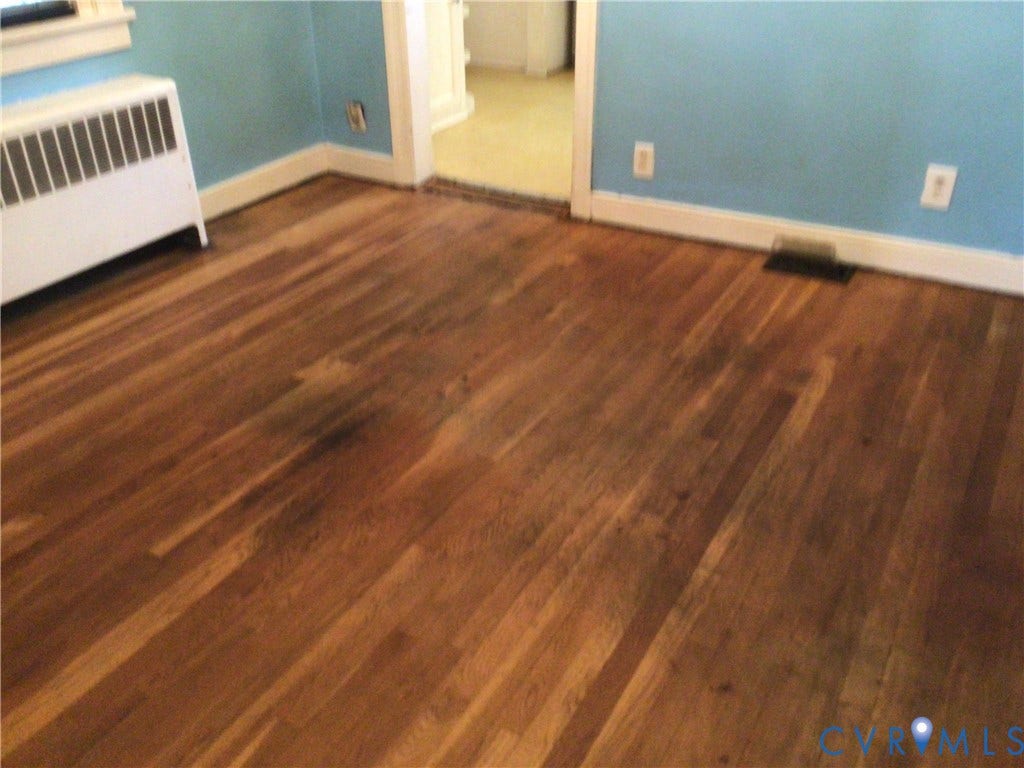 1307 Greystone Avenue, Richmond, VA 23224 Hardwood flooring featuring a natural grain finish and white wood trim