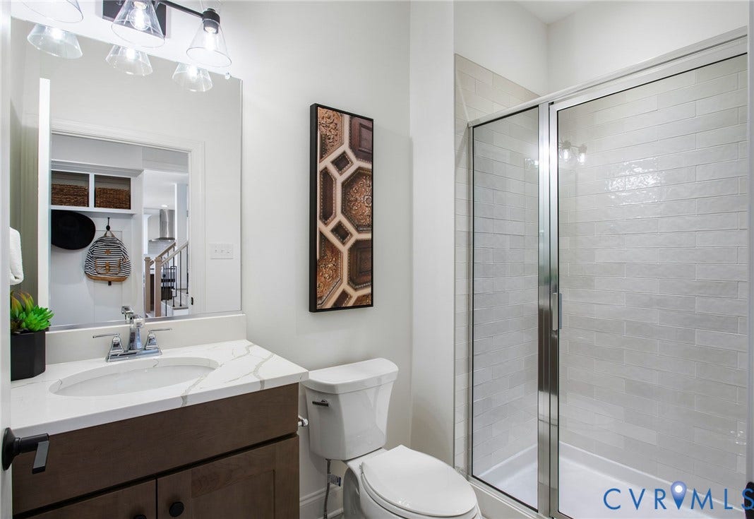2831 Old Pump Road, The Preserve At John Rolfe, Henrico, VA 23233 Vanity with a quartz countertop and an undermount sink, a framed mirror, and a walk-in shower with tile surround and glass enclosure