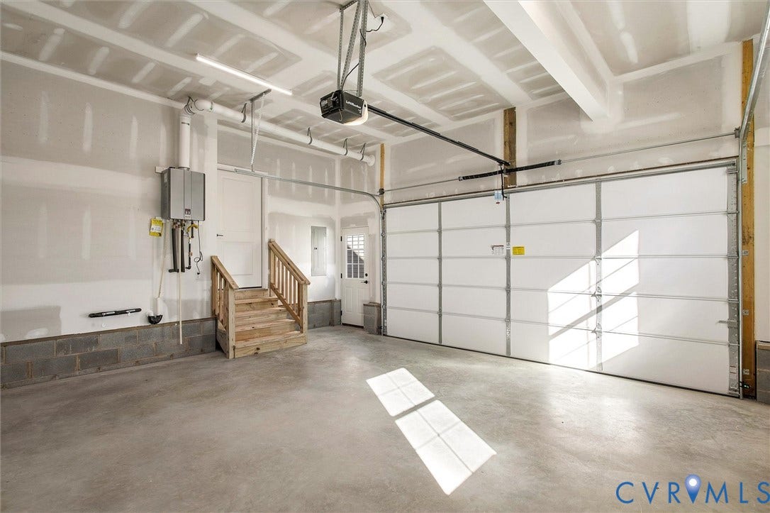2831 Old Pump Road, The Preserve At John Rolfe, Henrico, VA 23233 Concrete flooring, built-in wooden staircase, white panel garage door, wall-mounted water heater, and overhead lighting