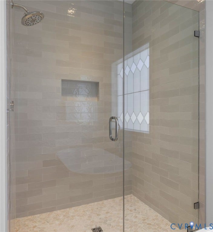 2831 Old Pump Road, The Preserve At John Rolfe, Henrico, VA 23233 Glass-enclosed shower with subway tile walls, a built-in shower niche, and a fixed showerhead