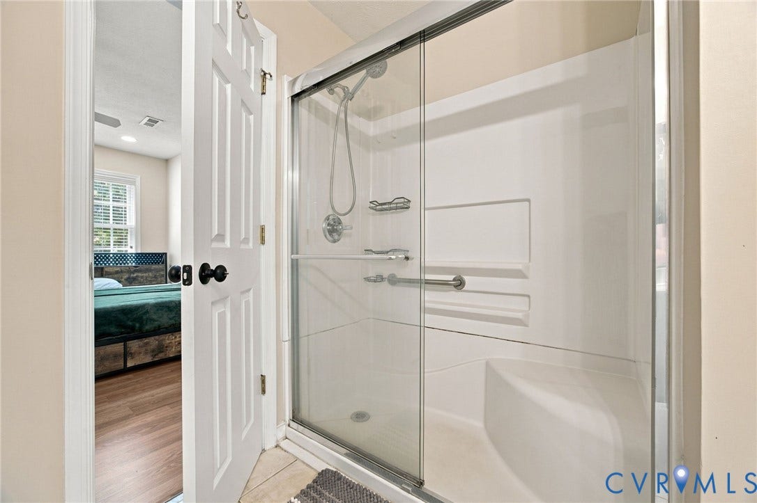 8119 Castle Grove Drive, Mechanicsville, VA 23111 Bthroom Walk-in shower featuring a glass sliding enclosure, built-in bench seat, integrated shelving, and adjustable handheld shower head