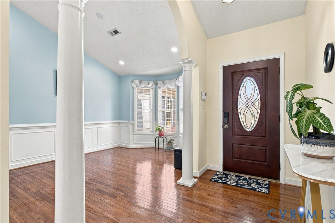 8119 Castle Grove Drive, Mechanicsville, VA 23111 Entryway featuring hardwood flooring, classic architectural columns, arched entry, wainscoting, and a decorative glass-insert entry door