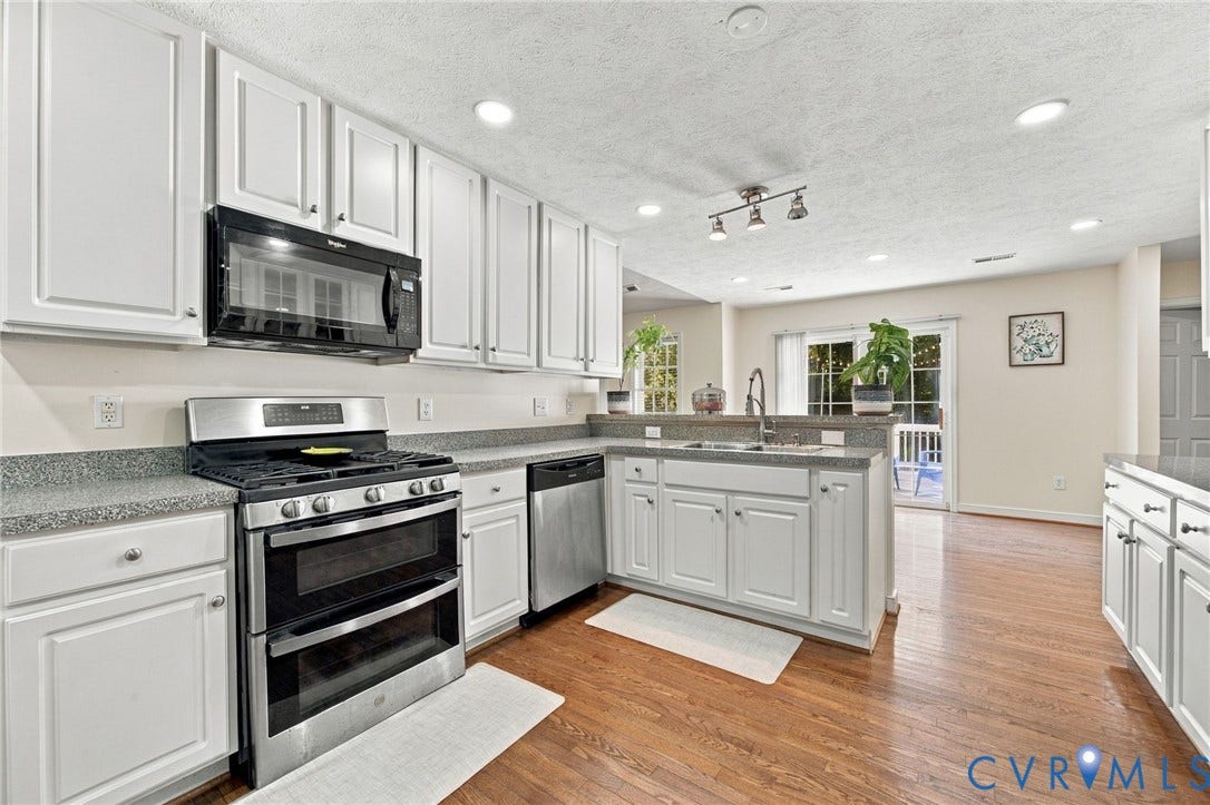 8119 Castle Grove Drive, Mechanicsville, VA 23111 Kitchen featuring white shaker-style cabinetry, speckled stone-finish countertops, stainless steel appliance suite, wood-finish flooring, and recessed ceiling lighting