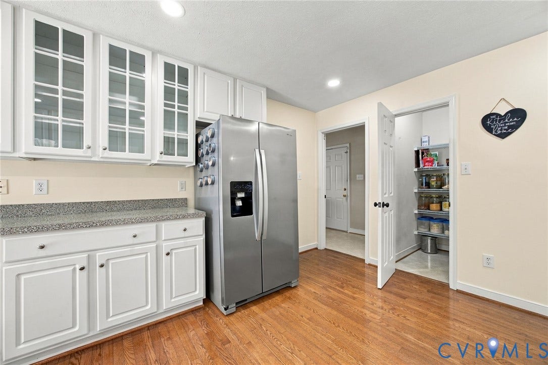 8119 Castle Grove Drive, Mechanicsville, VA 23111 Kitchen featuring white cabinetry with glass-front uppers, speckled stone-finish countertops, stainless steel side-by-side refrigerator, wood-finish flooring, and a walk-in pantry