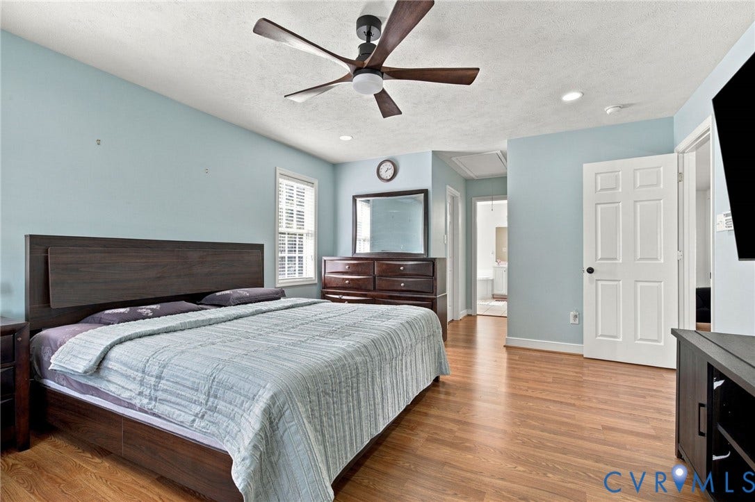 8119 Castle Grove Drive, Mechanicsville, VA 23111 Primary bedroom with Wood-finish flooring, ceiling fan with integrated lighting, multi-panel interior door, recessed lighting, and single-hung window with colonial grid pattern
