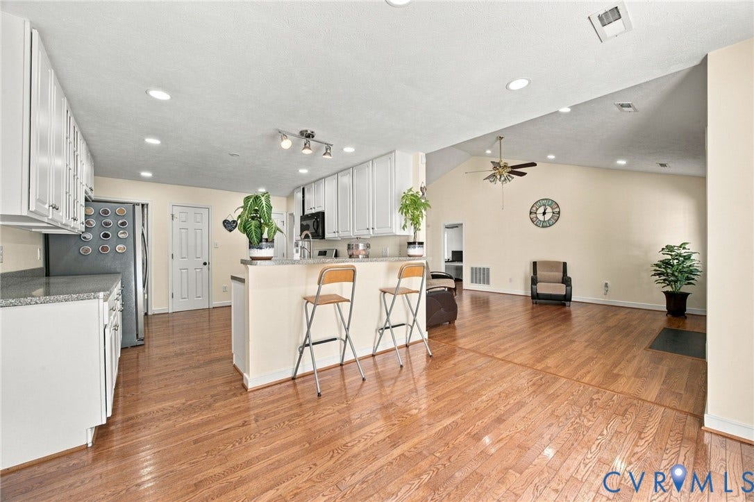 8119 Castle Grove Drive, Mechanicsville, VA 23111 Kitchen featuring white shaker-style cabinetry, solid-surface countertops, recessed lighting, and wood-finish flooring with vaulted ceilings