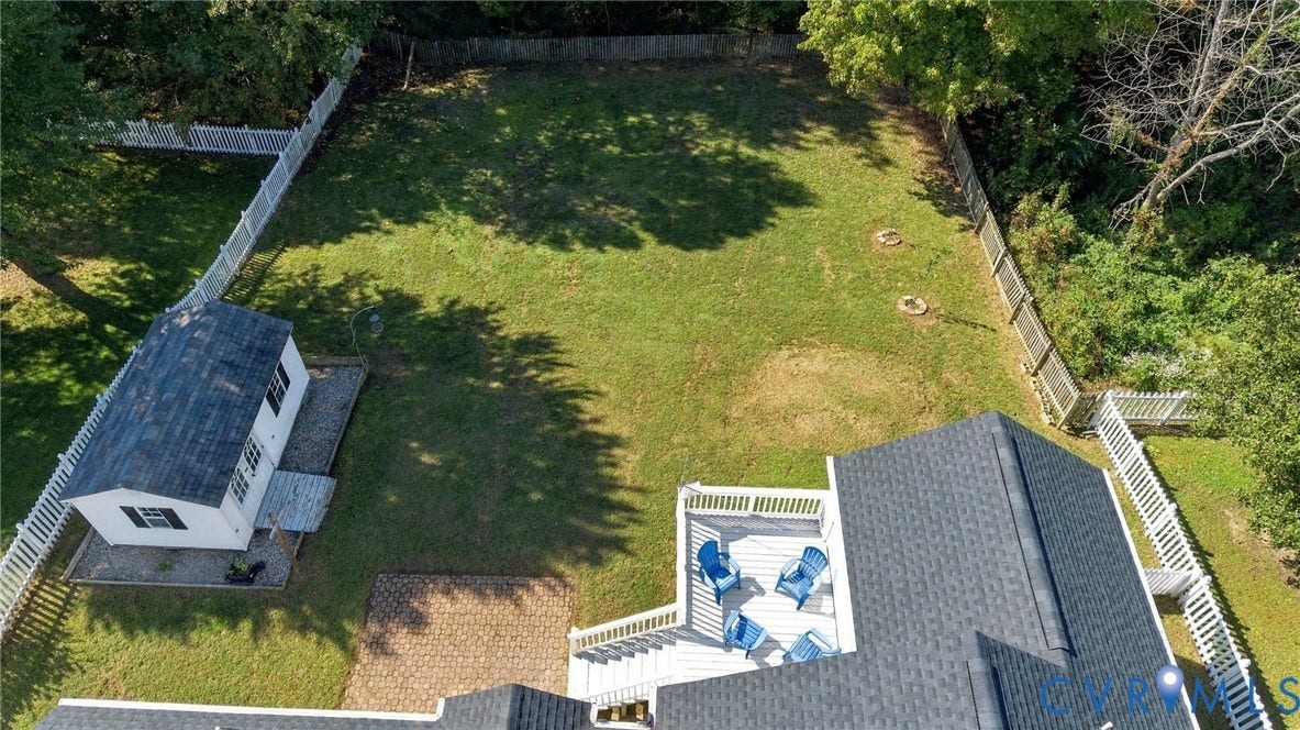 8119 Castle Grove Drive, Mechanicsville, VA 23111 Expansive fenced backyard featuring a large lawn, a detached storage structure, an elevated composite deck, and a paver patio