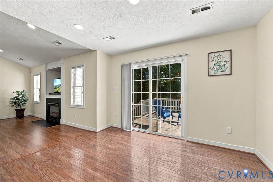 8119 Castle Grove Drive, Mechanicsville, VA 23111 Breakfast Area, featuring wood-finish flooring, recessed lighting, a fireplace with a black surround, and glass sliding doors