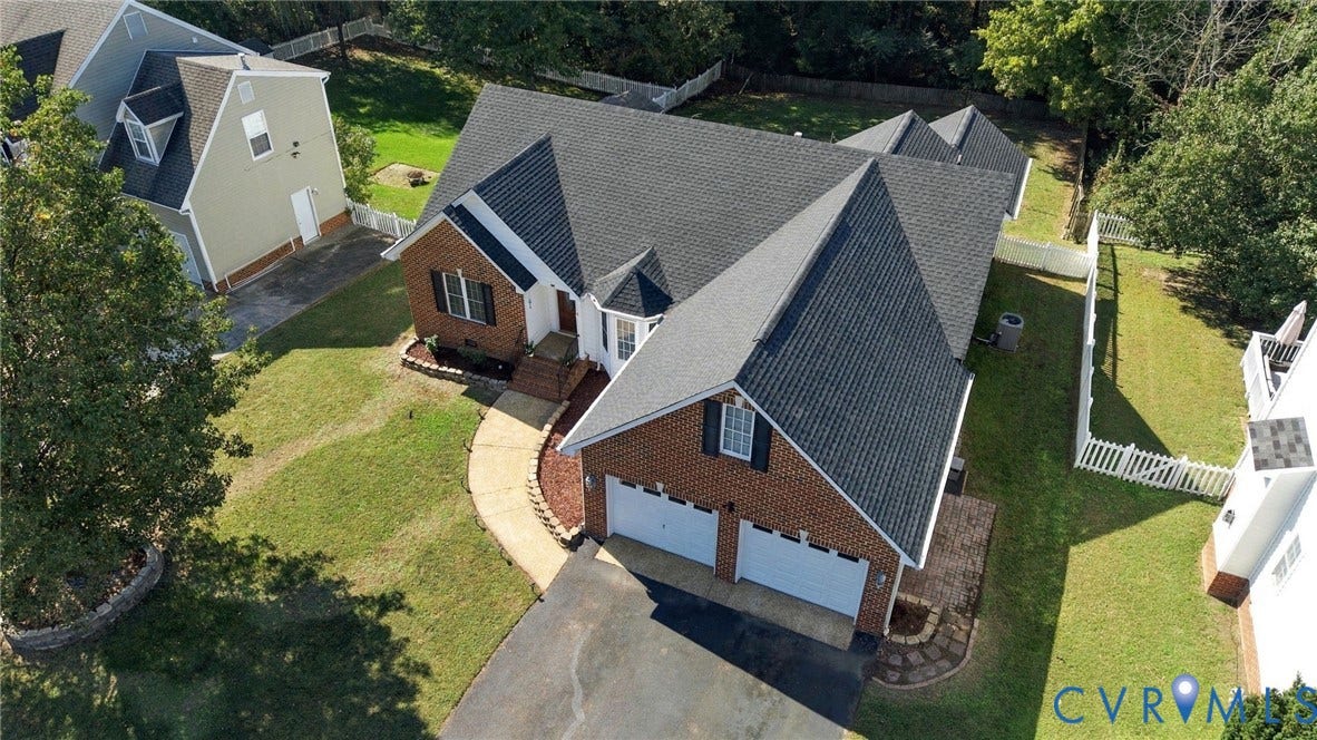 8119 Castle Grove Drive, Mechanicsville, VA 23111 Brick exterior featuring an asphalt shingle roof, a two-car garage, and a curved concrete walkway