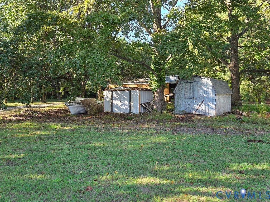 Expansive green space with mature trees and a storage shed