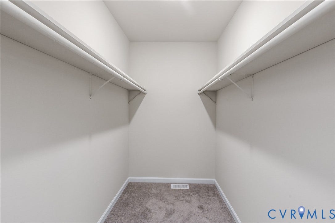 12089 Monterey Road, Ruther Glen, VA 22546 Walk-in storage space featuring neutral carpeting and dual-sided built-in shelving with integrated rods