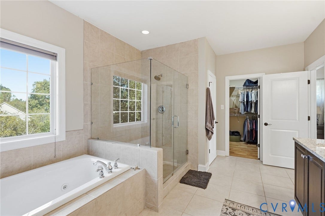 4502 Jennway Turn, Summer Lake, Moseley, VA 23120 Bathroom featuring a soaking tub, glass-enclosed walk-in shower with tile surround, stone-top vanity, and walk-in closet