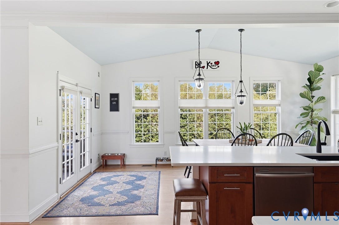 4502 Jennway Turn, Summer Lake, Moseley, VA 23120 Kitchen featuring a central island with a quartz countertop, wood-finish cabinetry, metal pendant lighting, double French doors, and multi-pane windows
