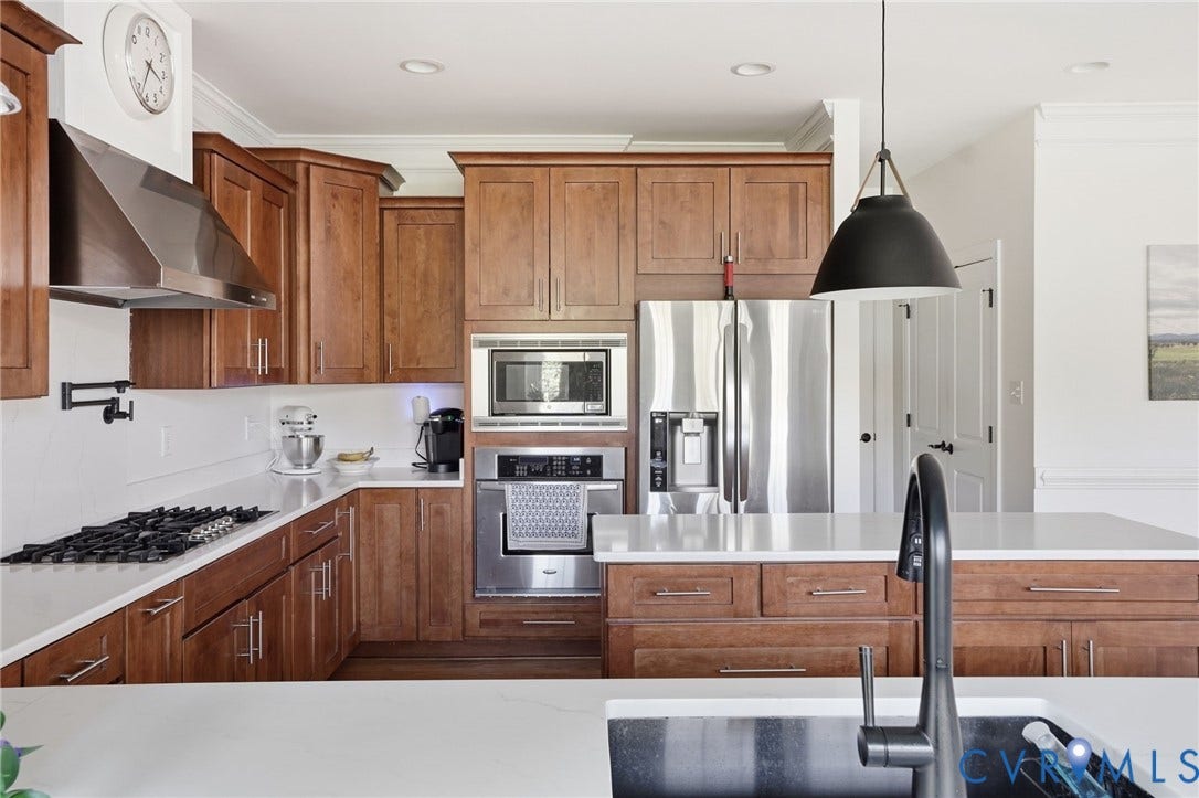 4502 Jennway Turn, Summer Lake, Moseley, VA 23120 Kitchen featuring rich-toned cabinetry, quartz countertops, stainless steel appliances, a built-in wall oven and microwave, and a matte black gooseneck faucet