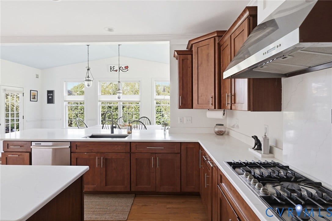 4502 Jennway Turn, Summer Lake, Moseley, VA 23120 Kitchen featuring custom wood cabinetry, expansive stone countertops, stainless steel gas cooktop with a professional-style range hood, integrated dishwasher, and wood-finish flooring