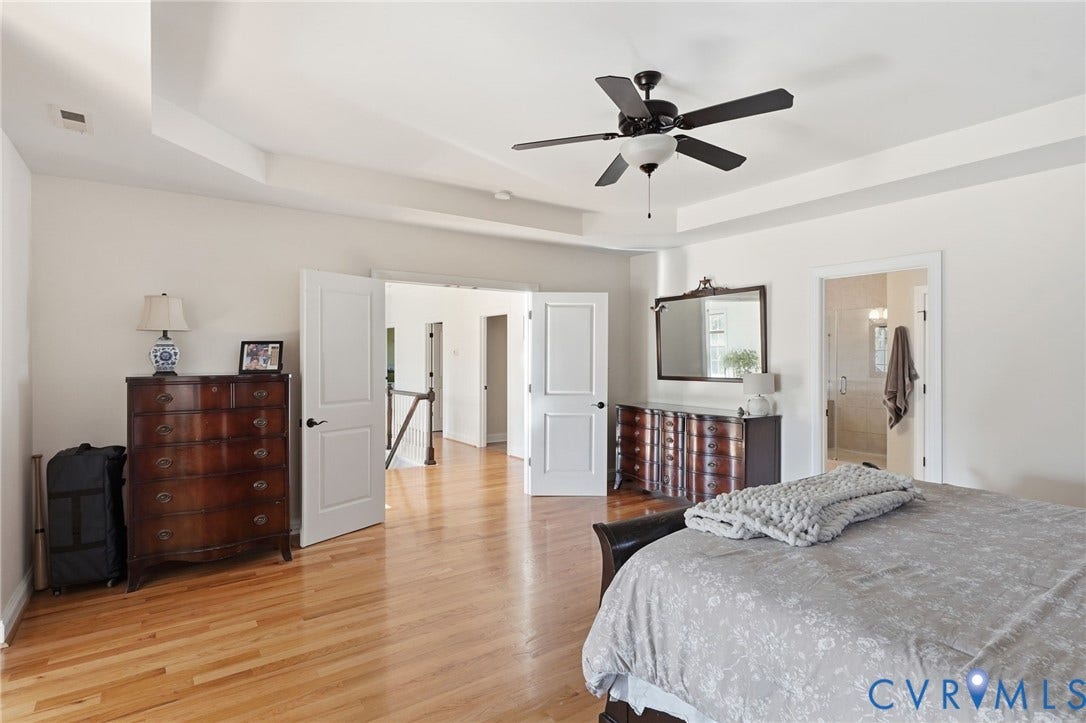 4502 Jennway Turn, Summer Lake, Moseley, VA 23120 Tray ceiling featuring a central matte black ceiling fan, wood-finish flooring, and multi-panel interior doors