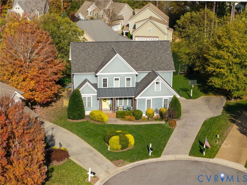 4502 Jennway Turn, Summer Lake, Moseley, VA 23120 Two-story residence featuring lap siding, metal roof accents, a covered front porch, and an attached concrete driveway