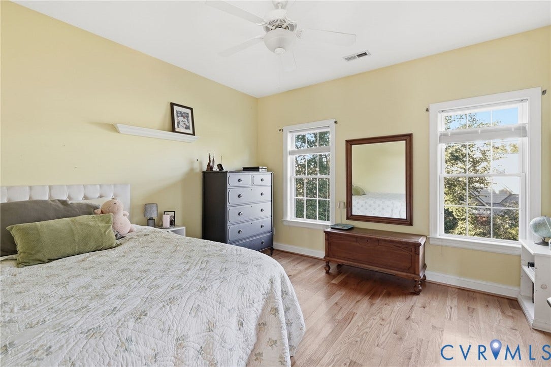 4502 Jennway Turn, Summer Lake, Moseley, VA 23120 Room featuring wood-finish flooring, two double-hung windows with white casings, a ceiling-mounted fan, and a built-in wall shelf