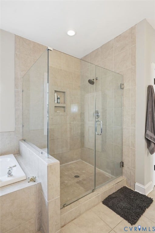 4502 Jennway Turn, Summer Lake, Moseley, VA 23120 Glass-enclosed shower with a polished chrome showerhead, integrated tiled wall niches, tile surround, and adjacent built-in soaking tub