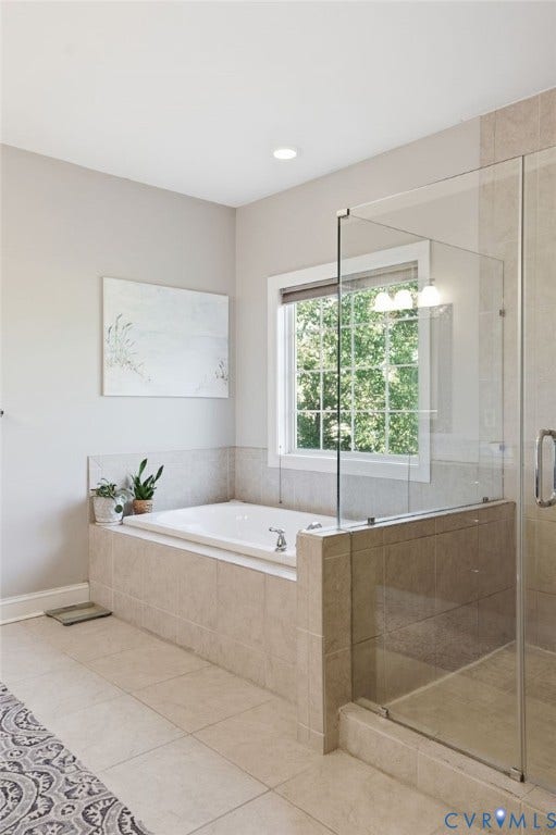 4502 Jennway Turn, Summer Lake, Moseley, VA 23120 Bathroom featuring a built-in soaking tub with a tile surround, glass-enclosed shower, neutral large-format floor tile, and a window with grid muntins