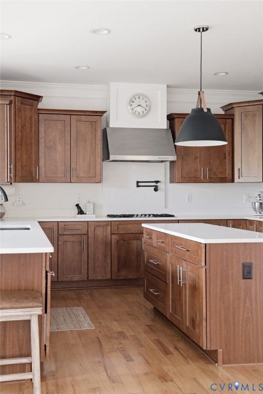 4502 Jennway Turn, Summer Lake, Moseley, VA 23120 Kitchen featuring stained wood cabinetry, white countertops, stainless steel range hood, matte black pot filler faucet, and pendant lighting