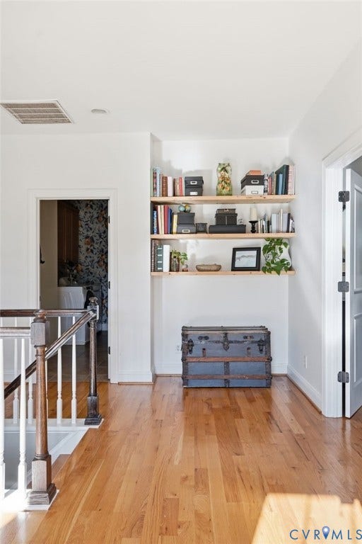 4502 Jennway Turn, Summer Lake, Moseley, VA 23120 Built-in wall shelving, wood-finish flooring, and a staircase featuring a white balustrade with a contrasting stained-wood handrail