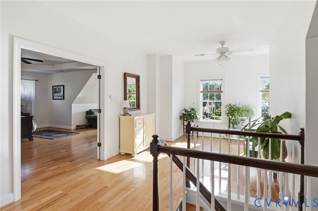 4502 Jennway Turn, Summer Lake, Moseley, VA 23120 Landing area featuring wood-finish flooring, multi-pane windows, and a staircase with a white balustrade and dark wood handrail