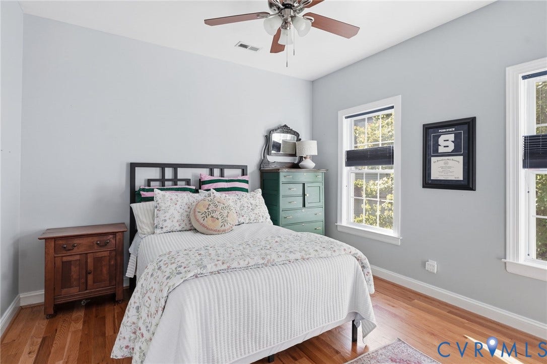 4502 Jennway Turn, Summer Lake, Moseley, VA 23120 Neutral-toned room featuring wood-finish flooring, two windows with adjustable shades, and a ceiling-mounted fan with integrated lighting