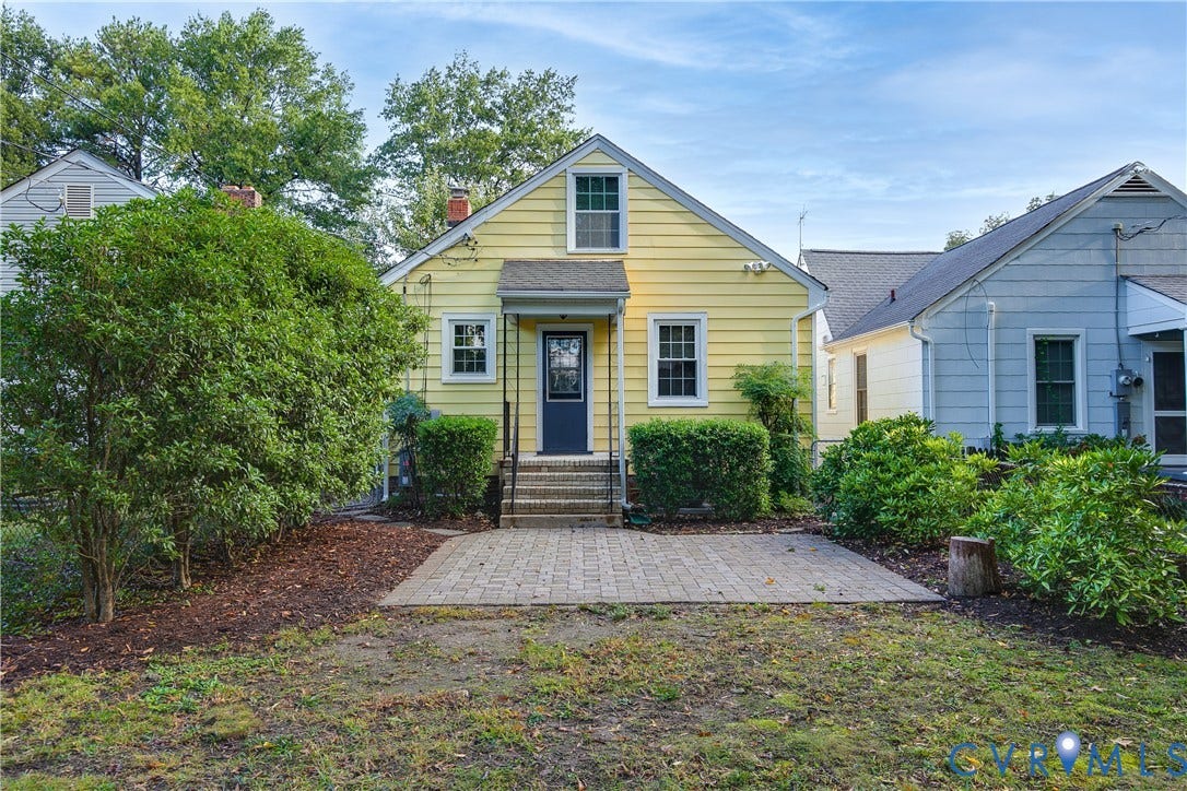 3006 Porter Street, Richmond, VA 23225 Exterior rear elevation featuring yellow horizontal lap siding, a brick-paver patio, stone-surfaced steps, and a covered entry