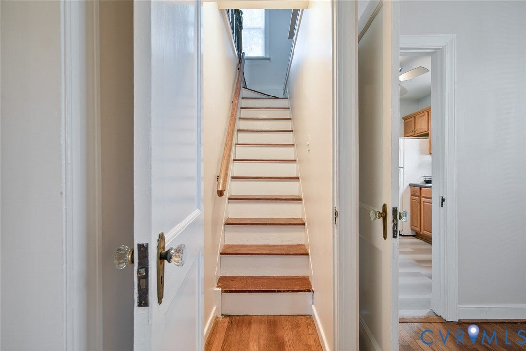 3006 Porter Street, Richmond, VA 23225 Staircase featuring wood treads and a natural wood-finish handrail, flanked by traditional solid-core doors with vintage glass door knobs
