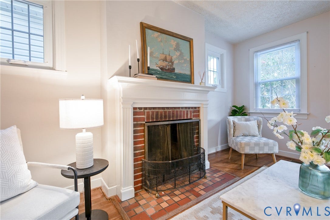 3006 Porter Street, Richmond, VA 23225 Traditional fireplace featuring a white wood-trimmed mantel, red brick surround, and a coordinating tile hearth