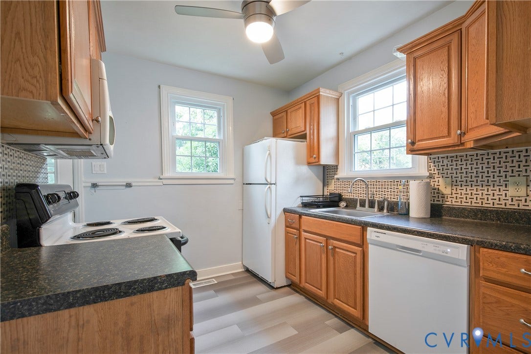 3006 Porter Street, Richmond, VA 23225 Kitchen featuring wood cabinetry, dark countertops, patterned tile backsplash, multi-tonal wood-finish flooring, and ceiling-mounted fan