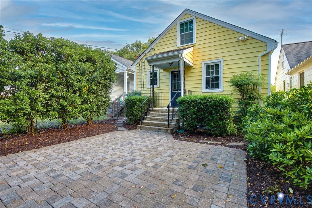 3006 Porter Street, Richmond, VA 23225 Exterior featuring yellow horizontal siding, a paved stone patio, concrete steps with decorative metal railings, and a covered entryway