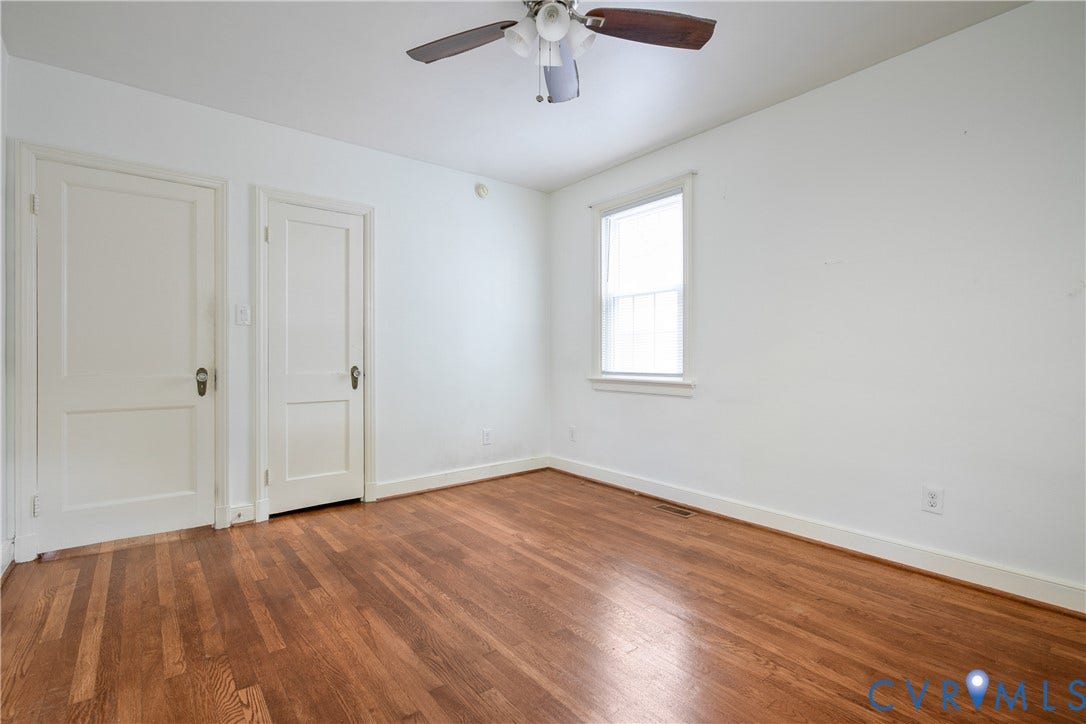 3006 Porter Street, Richmond, VA 23225 Room featuring wood-finish flooring, two white paneled doors, a single hung window, and a ceiling-mounted light fixture with a fan
