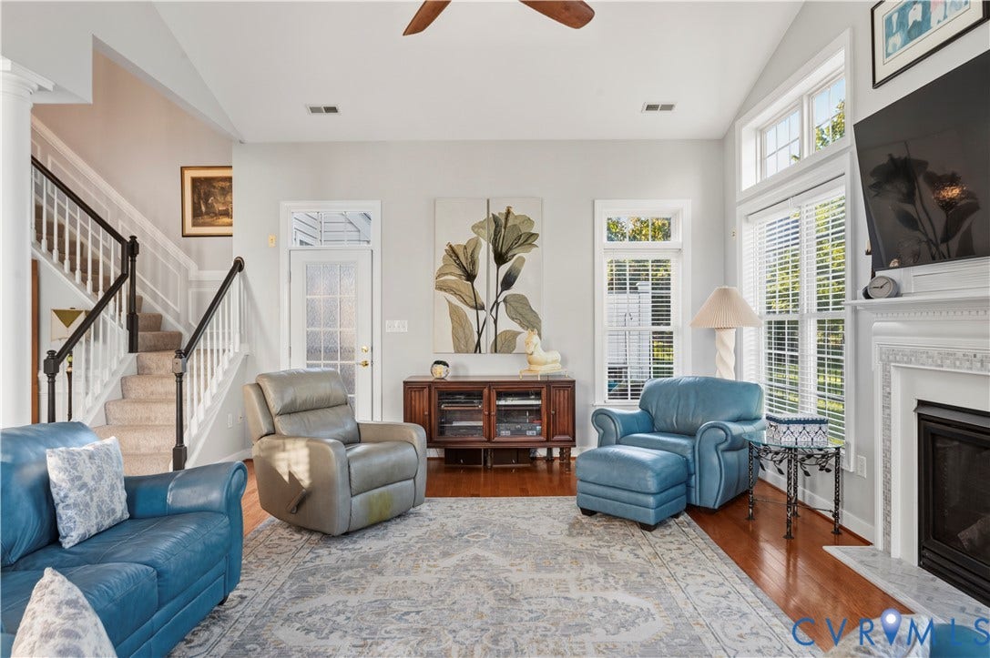3360 Manor Grove Circle, Glen Allen, VA 23059 Vaulted ceilings, wood-finish flooring, fireplace with a decorative mantel, transom windows, and a staircase featuring a white balustrade with dark handrail