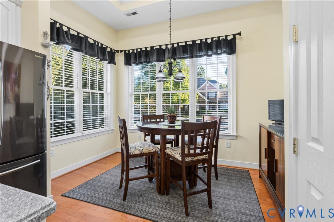 3360 Manor Grove Circle, Glen Allen, VA 23059 Sun-filled corner dining area featuring hardwood flooring, multi-pane windows, and a multi-arm pendant light fixture