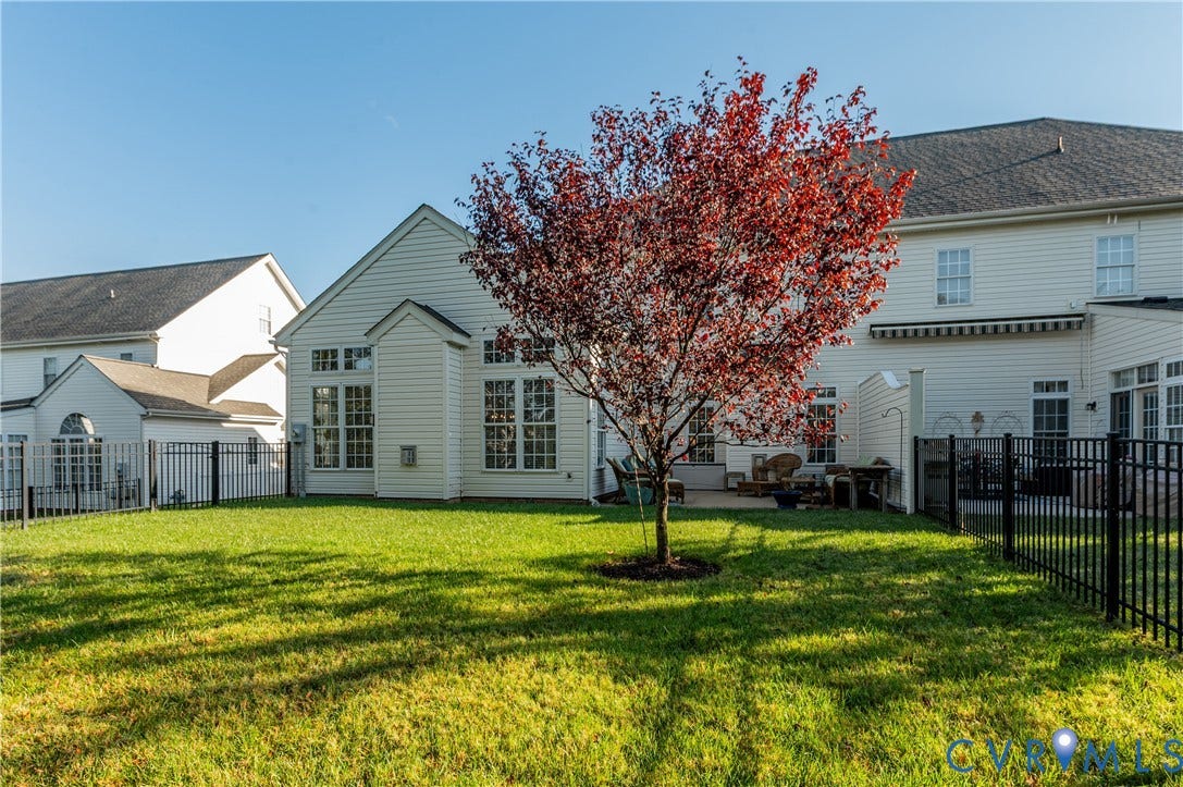 3360 Manor Grove Circle, Glen Allen, VA 23059 Rear yard featuring a manicured lawn, black metal perimeter fencing, mature tree, and concrete patio