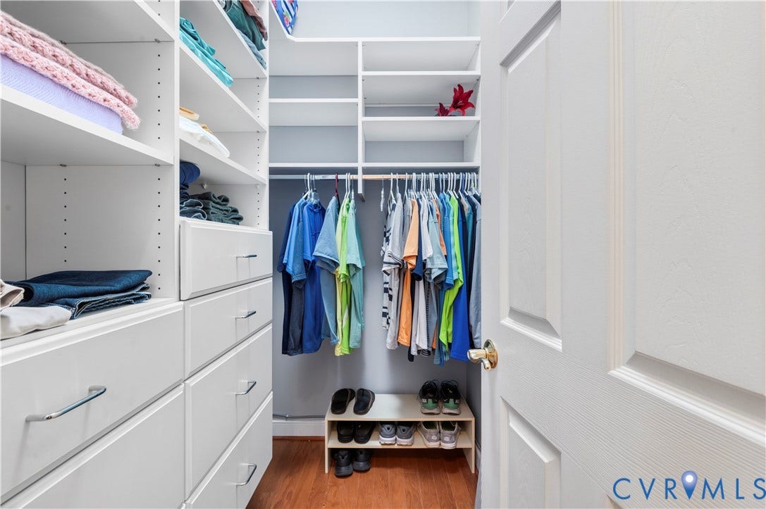 3360 Manor Grove Circle, Glen Allen, VA 23059 Walk-in closet featuring white built-in shelving, multiple pull-out drawers with silver-tone pulls, integrated clothing rods, and wood-finish flooring
