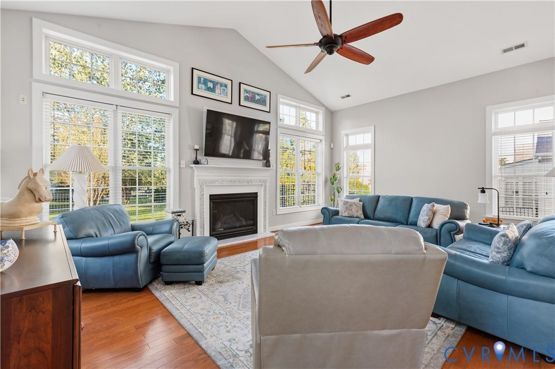 3360 Manor Grove Circle, Glen Allen, VA 23059 Vaulted ceilings, a gas fireplace with a decorative mantel, wood-finish flooring, and multiple large windows with muntins