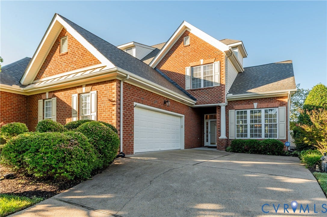 3360 Manor Grove Circle, Glen Allen, VA 23059 Traditional brick exterior featuring a multi-gabled roofline, concrete driveway, attached garage, and multi-pane windows with louvered shutters