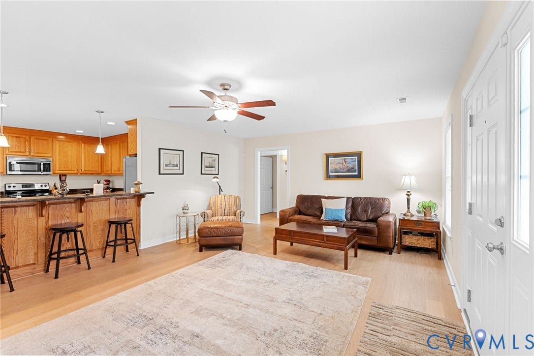 Large family room with wood floors, ceiling fan. Open floor plan.