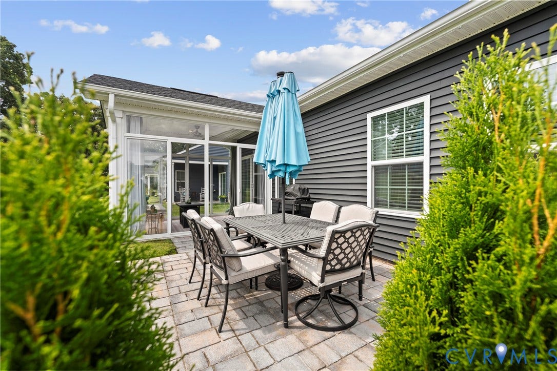Stone paver patio featuring a covered screened-in porch with ceiling fan and horizontal siding exterior