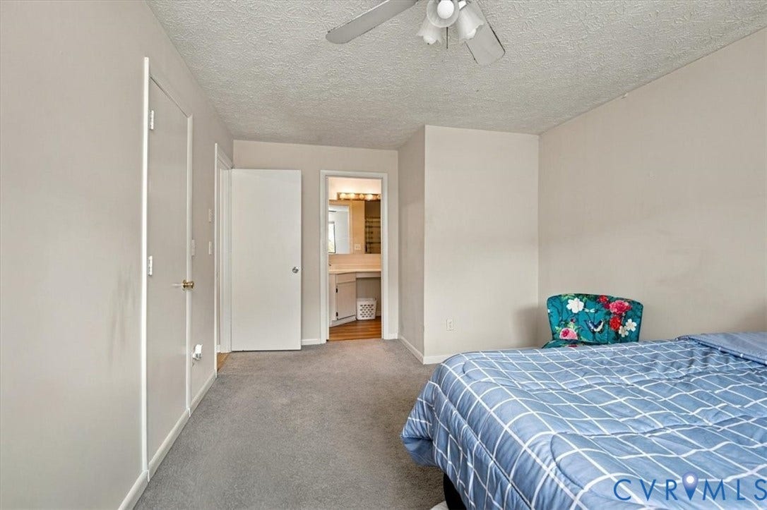 Interior space featuring neutral wall tones, wall-to-wall carpeting, and a ceiling-mounted fan with integrated lighting