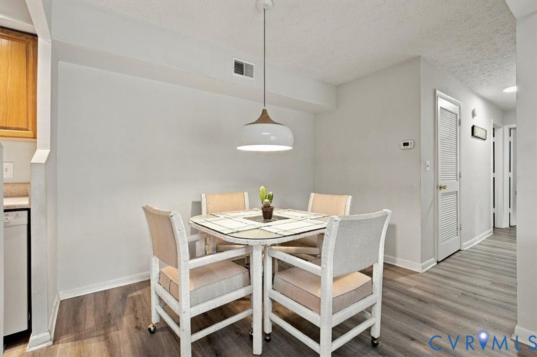 Neutral-toned walls, wood-finish flooring, and a modern dome pendant light