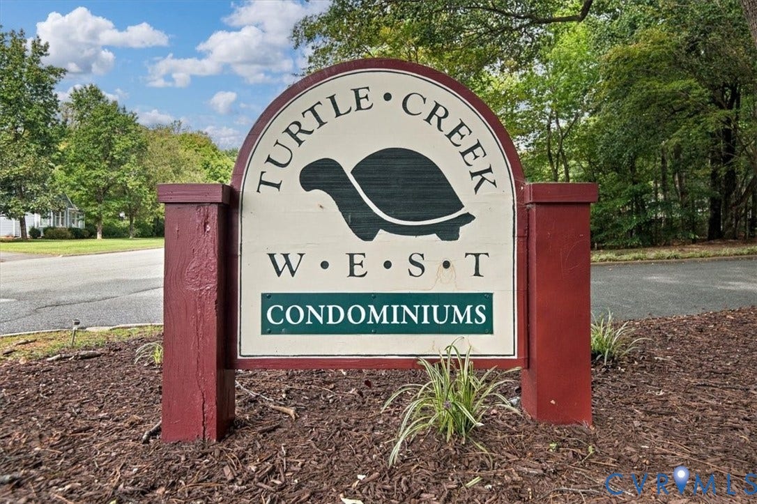 Turtle Creek West monument sign featuring painted wood pillars and landscaped mulch beds