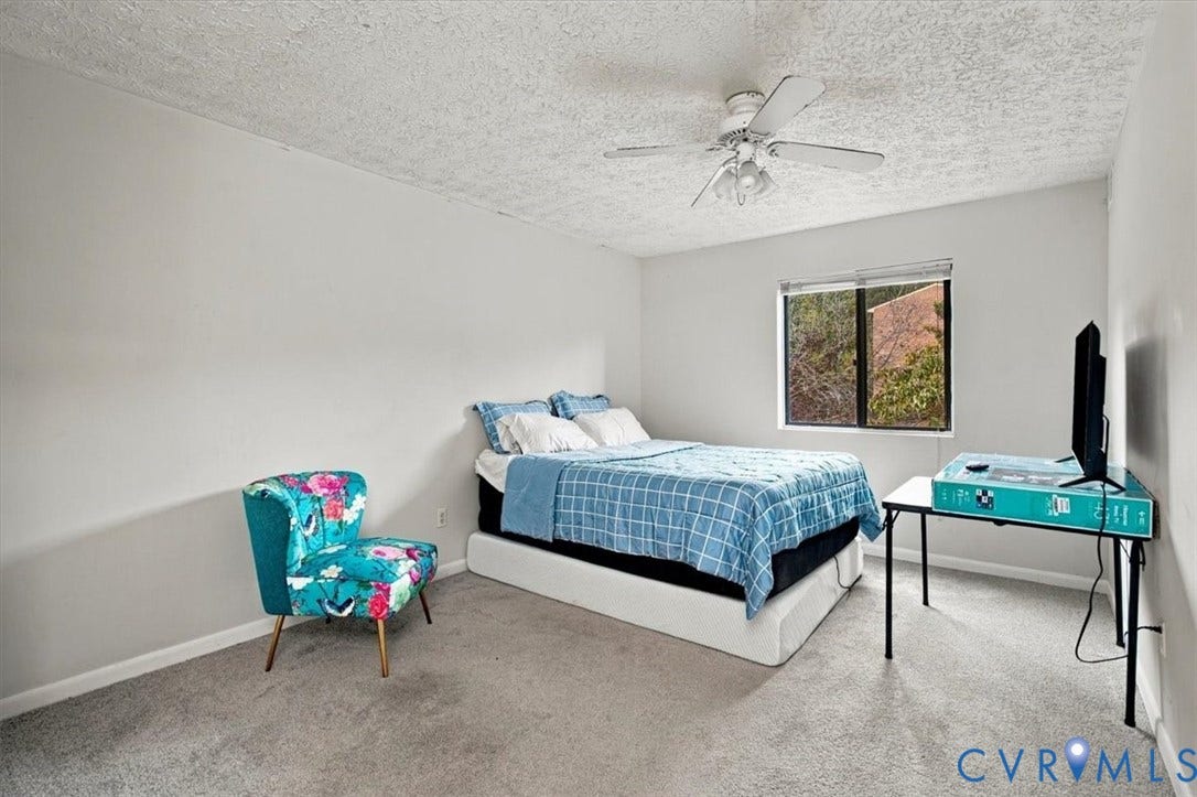 Neutral-toned walls, wall-to-wall carpeting, window with exterior exposure, and ceiling-mounted light fixture with fan